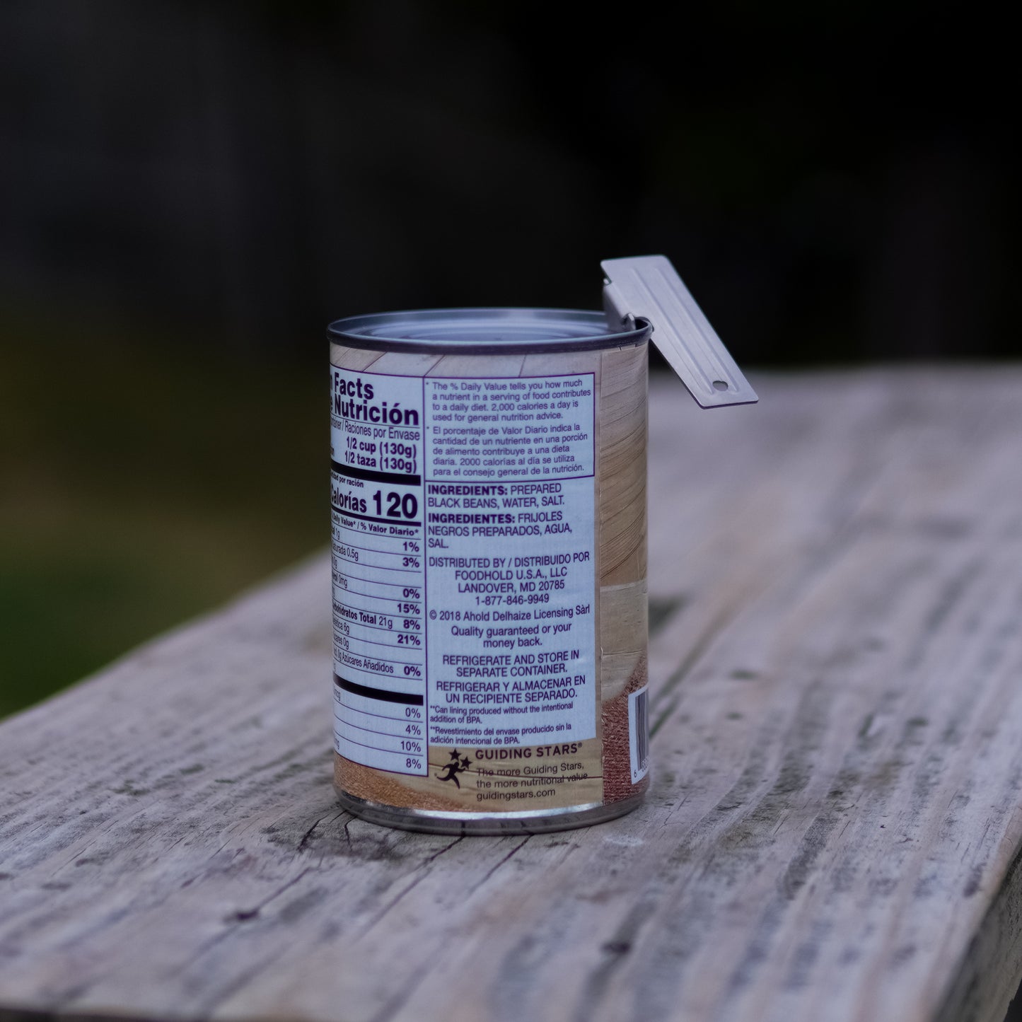Can of food with nutritional label on a wooden surface