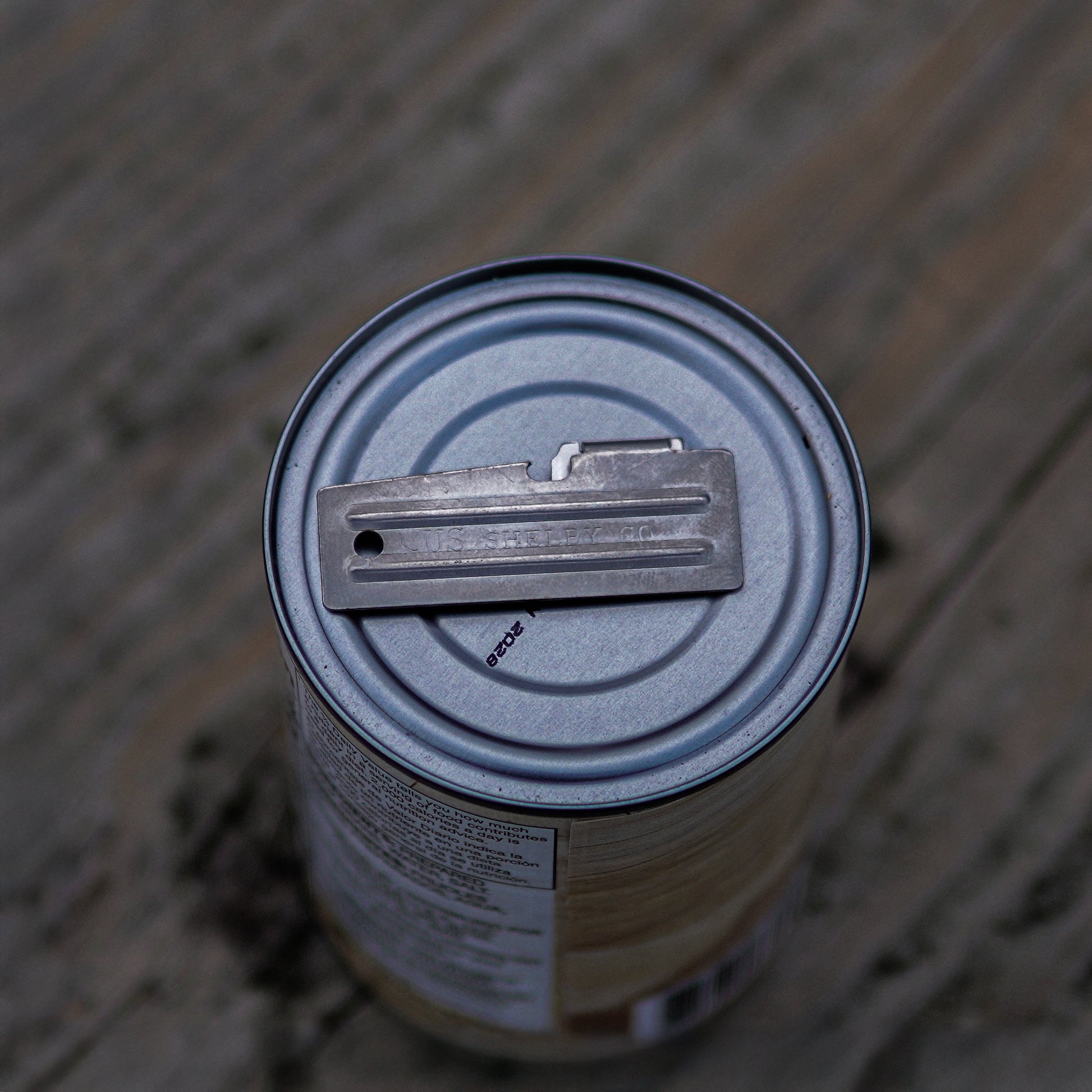 Metal can with a key attached on a wooden surface